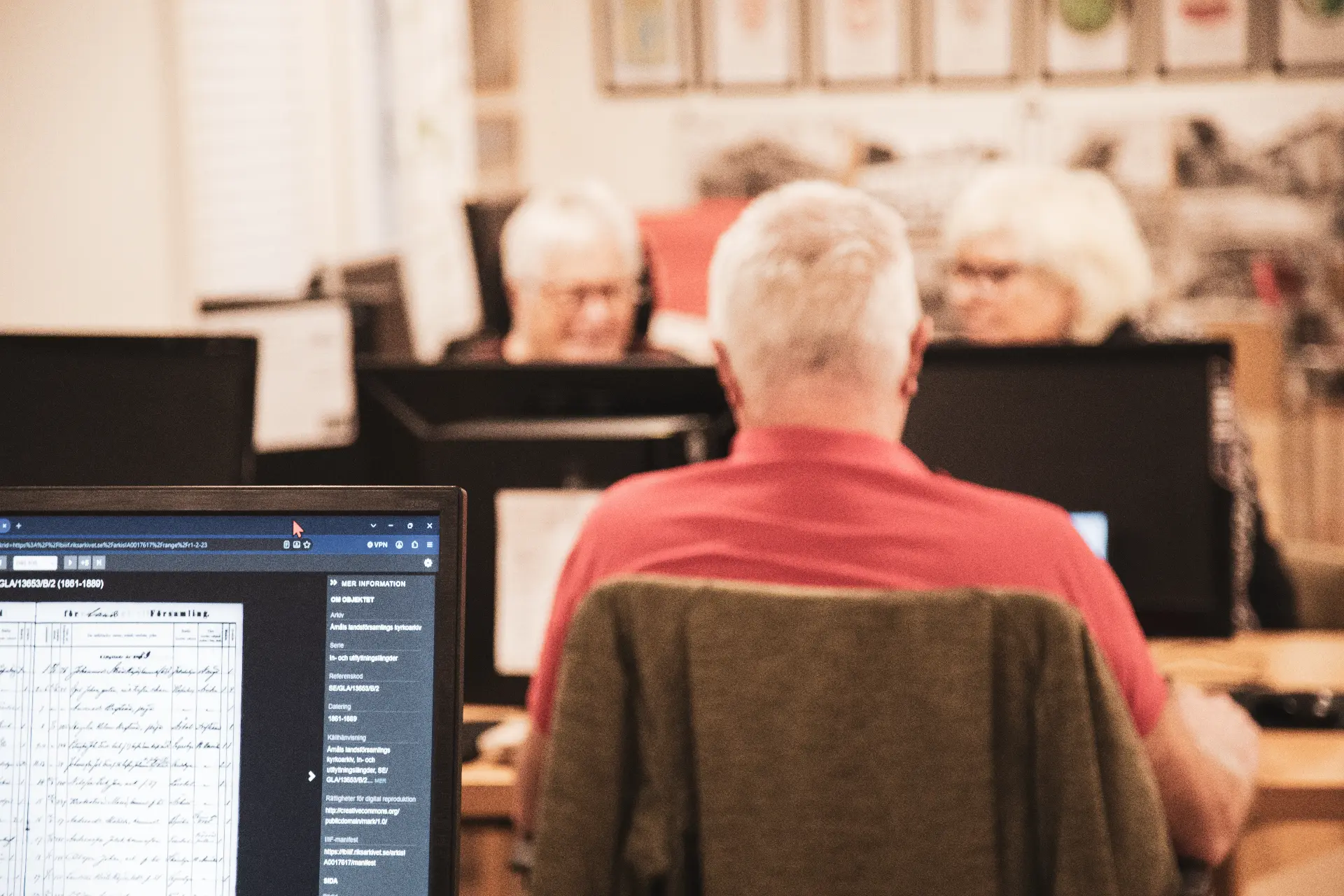 Person vid datorskärm med en digitaliserad kyrkobok från Riksarkivet